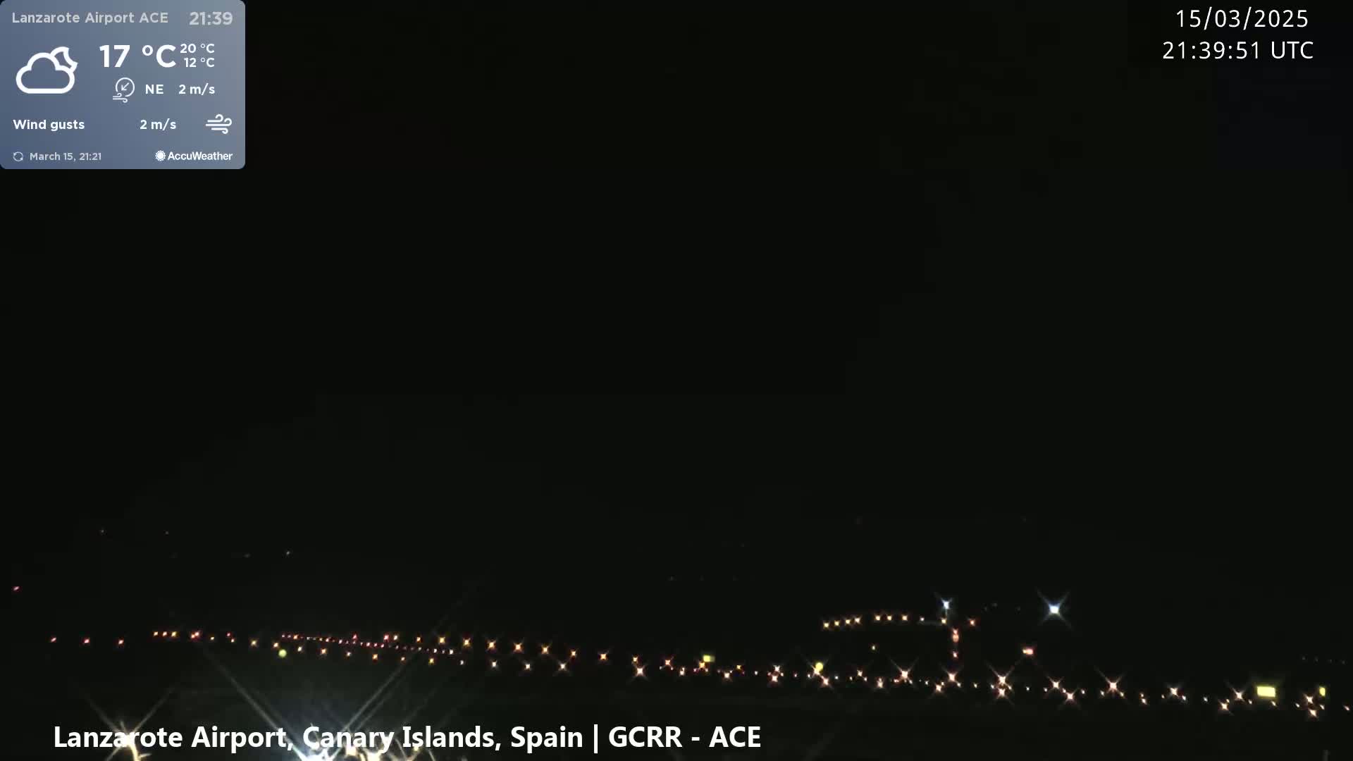 A nighttime long shot of an airport runway with faint lights visible in the distance under a clear, dark sky.