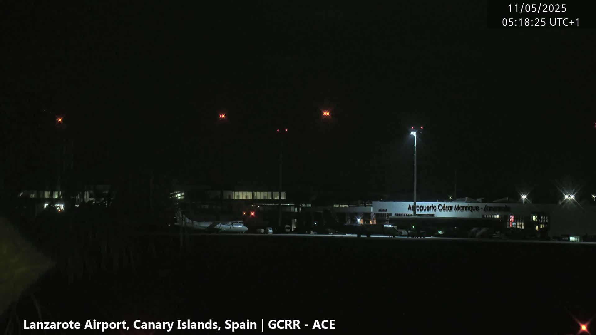 A nighttime view of an airport with several planes on the tarmac under a clear, dark sky.