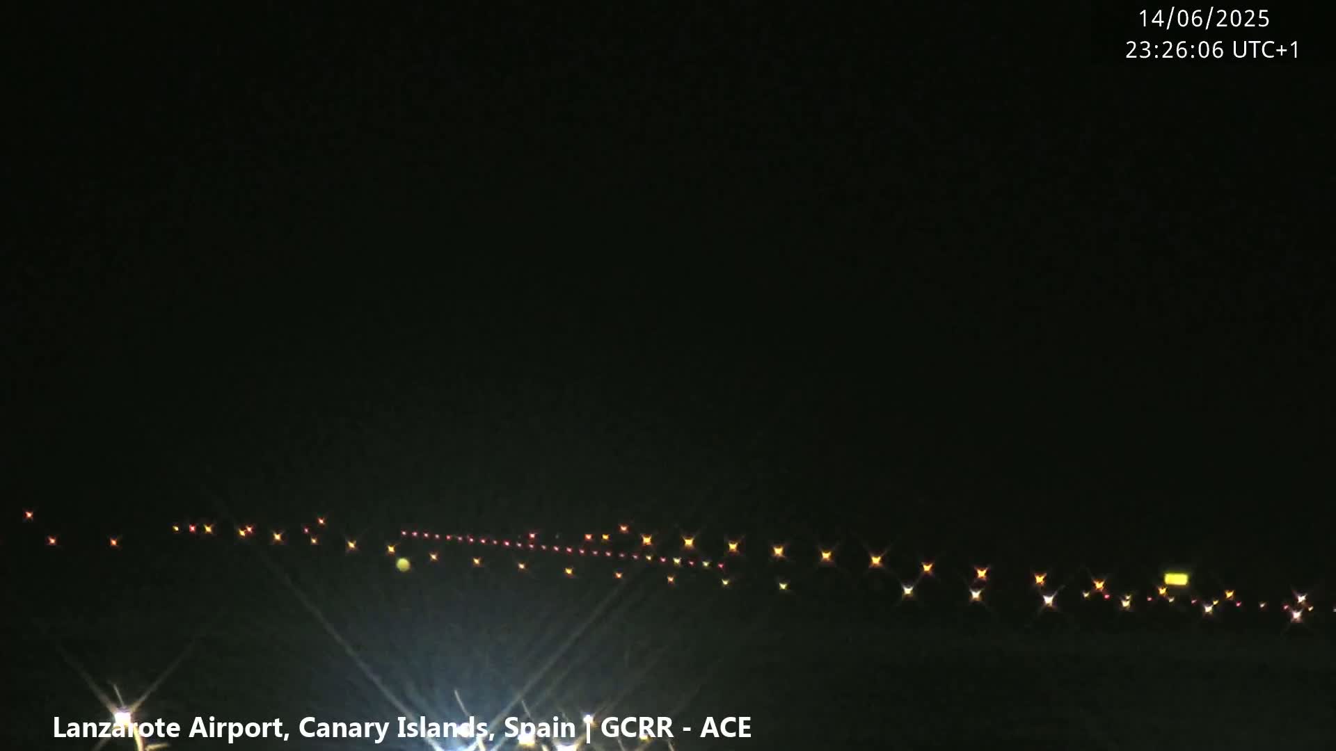 A hazy, overcast day shows an airport runway with a calm ocean in the background.