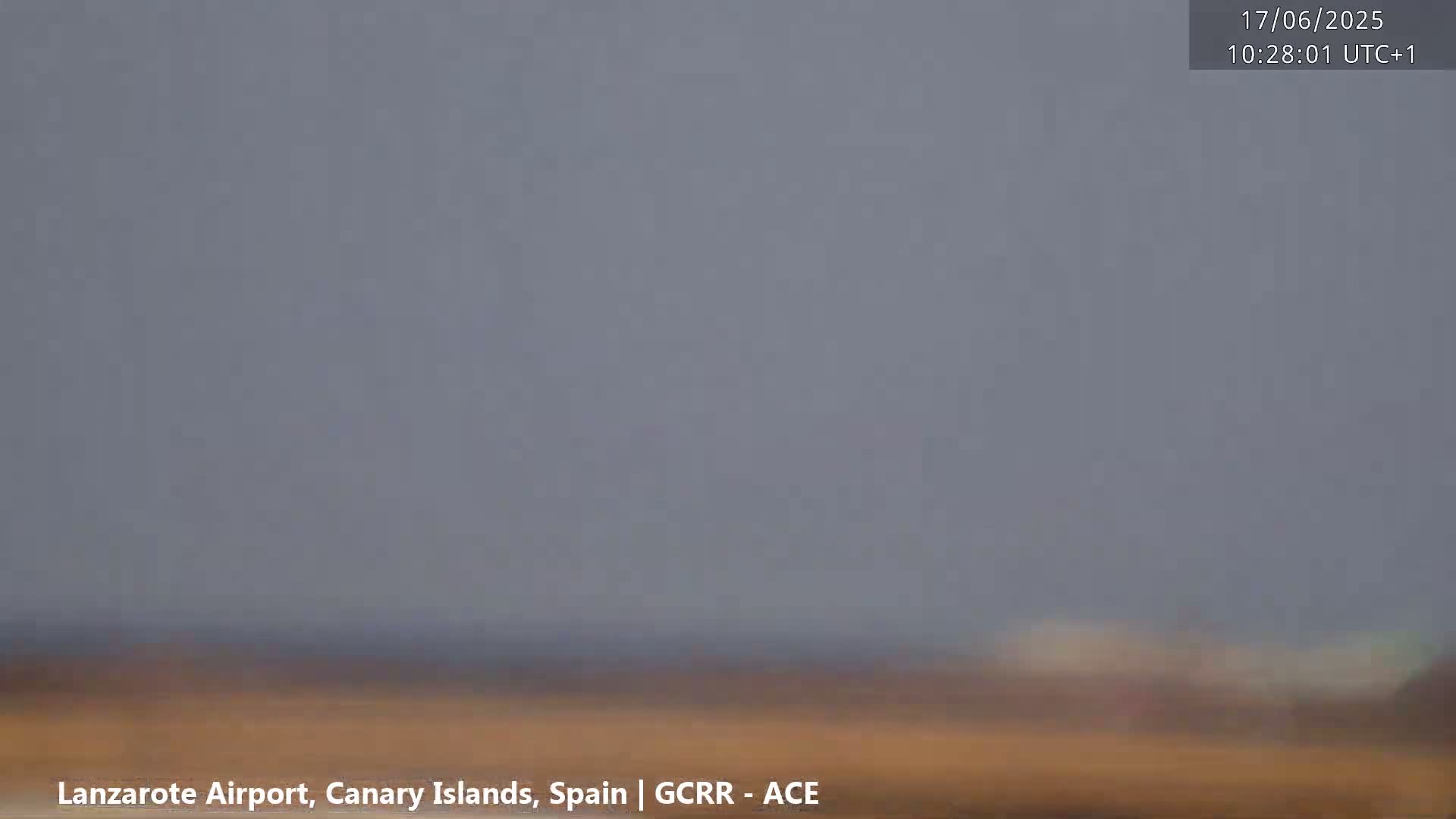 A hazy, overcast sky hangs over a flat, brownish landscape.