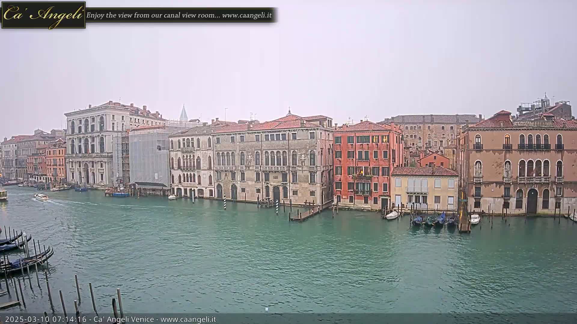 A canal in Venice, Italy, shows several multi-story buildings on either side under an overcast sky.