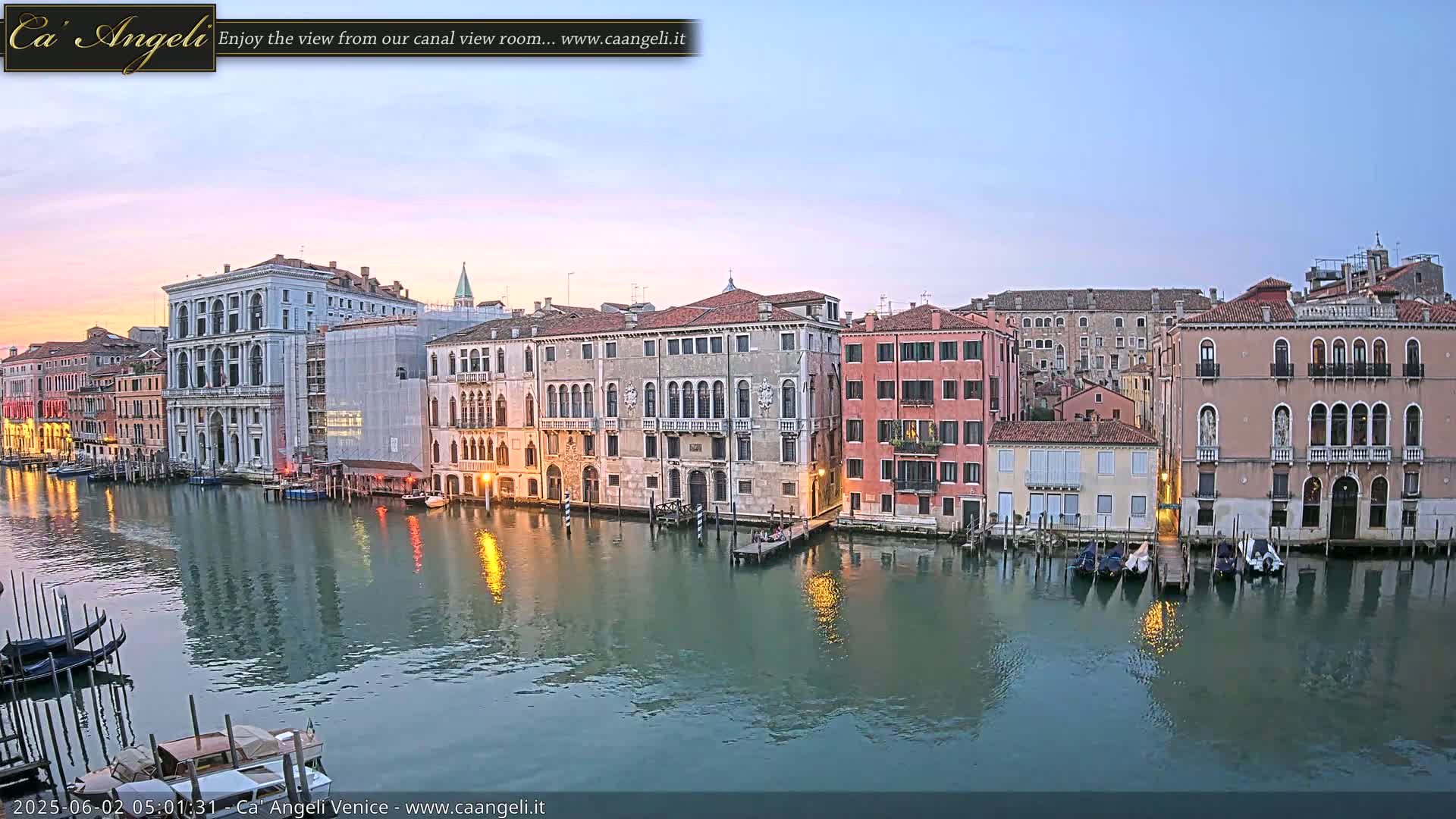 A tranquil canal in Venice at dawn, lined with historic buildings reflecting in the calm water.