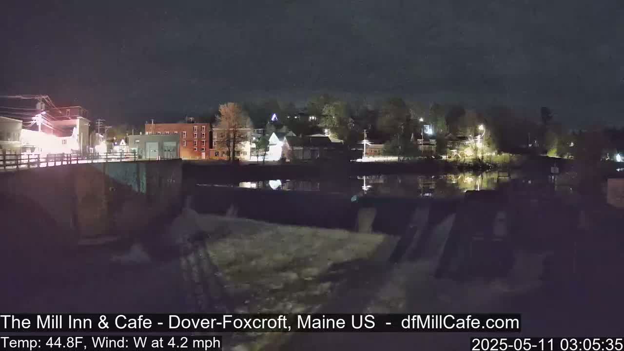 A nighttime view of a town across a body of water, under a clear, dark sky.