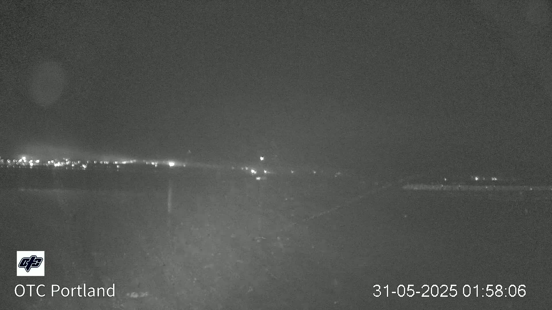 A nighttime long shot shows a distant line of lights under a dark, clear sky.