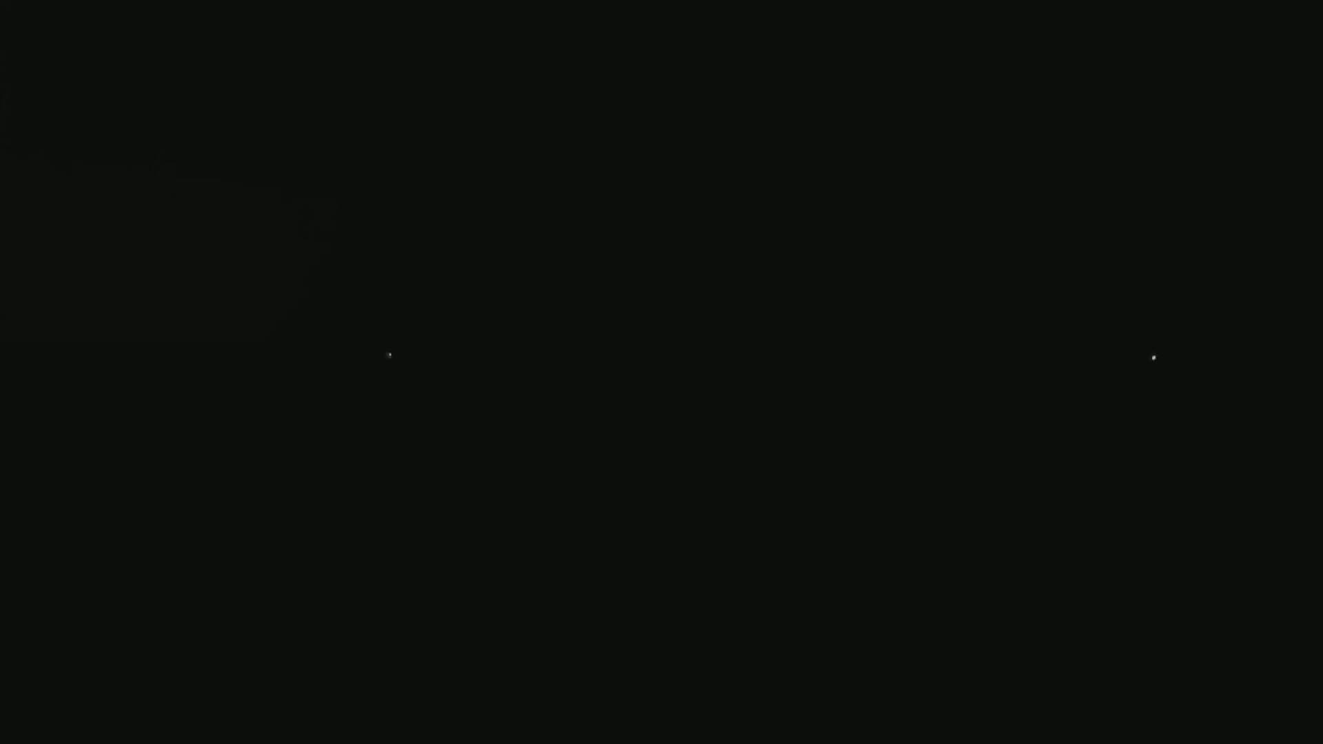 A mostly black image shows two very small, faint, white lights in the darkness.