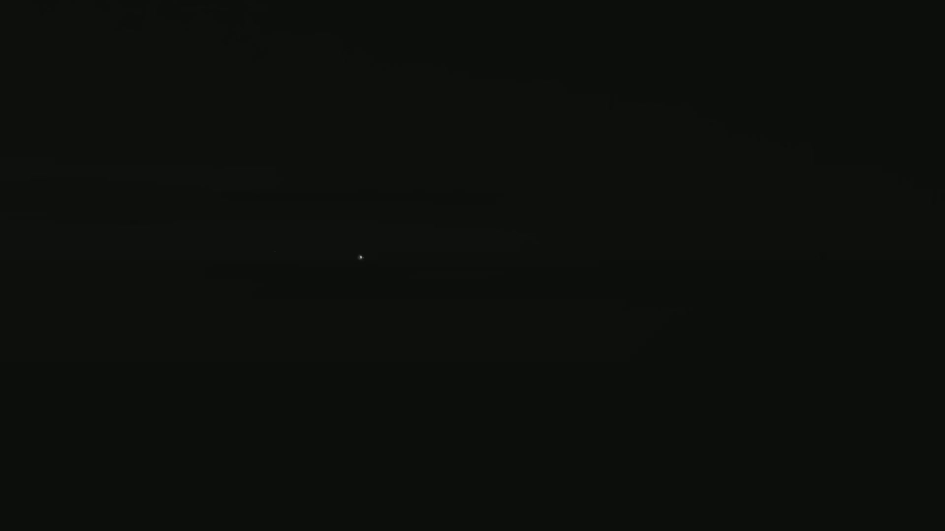 A very faint light is visible in the center of a mostly dark image.