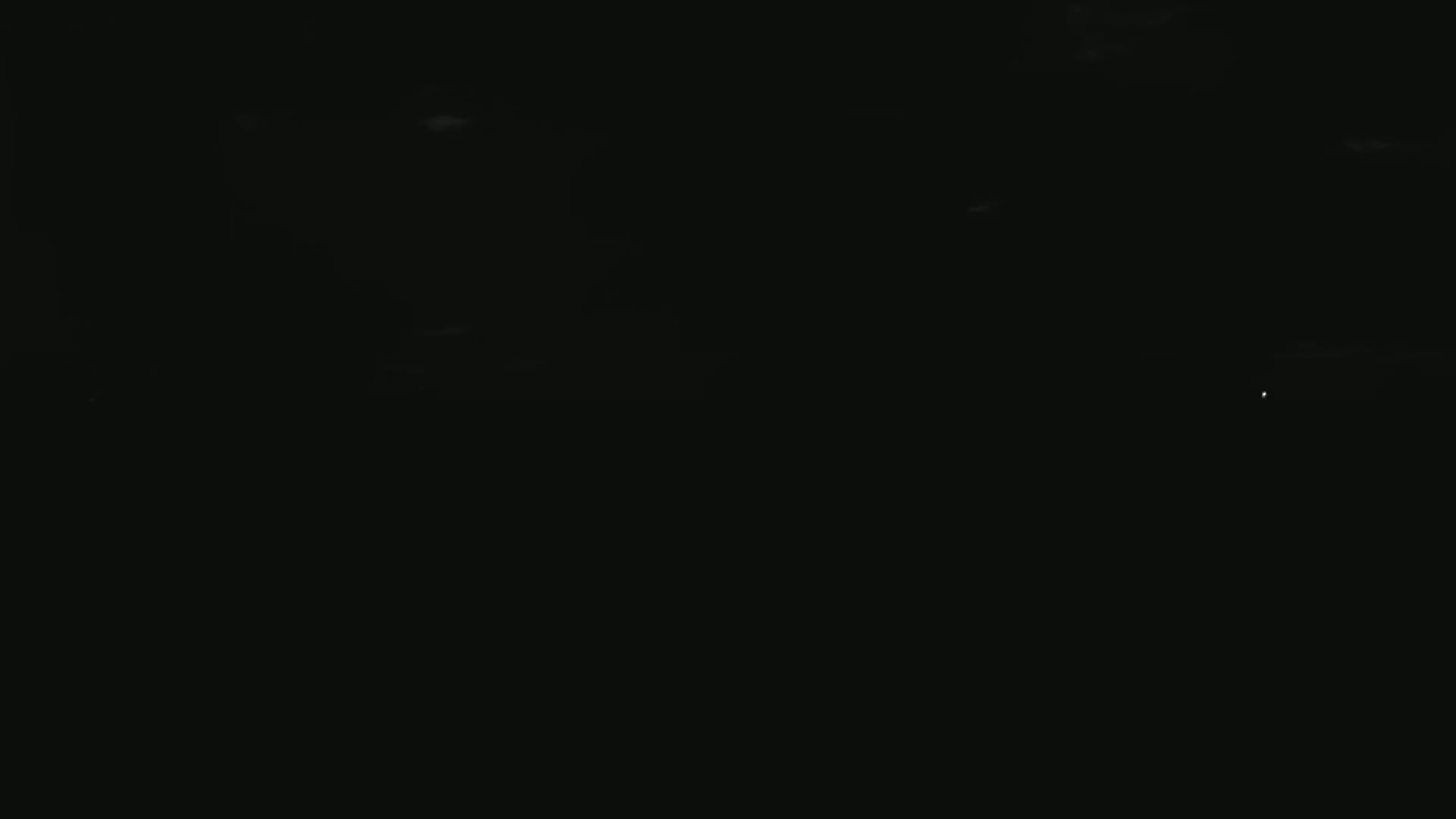 A dark night sky with a few faint clouds and a single distant light source.