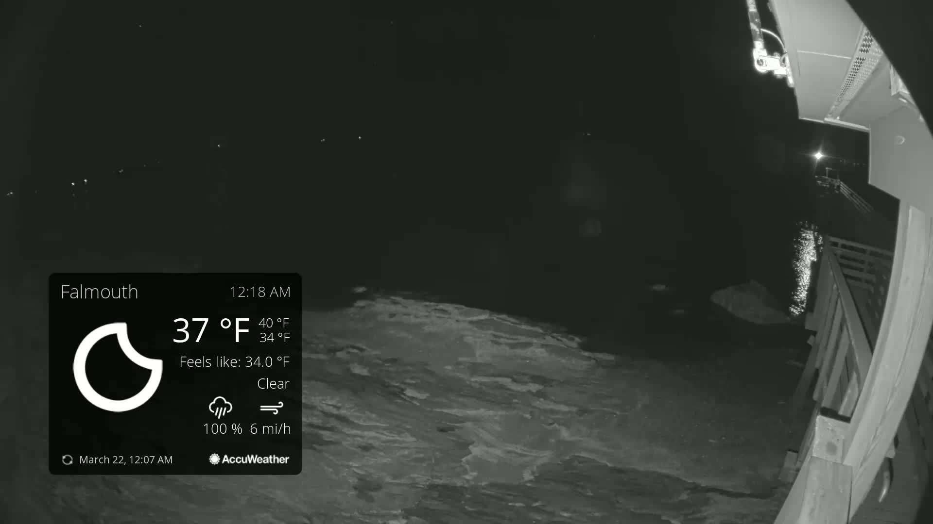 A nighttime, clear view of a body of water from a wooden pier, with a 37°F temperature and 6 mph wind.