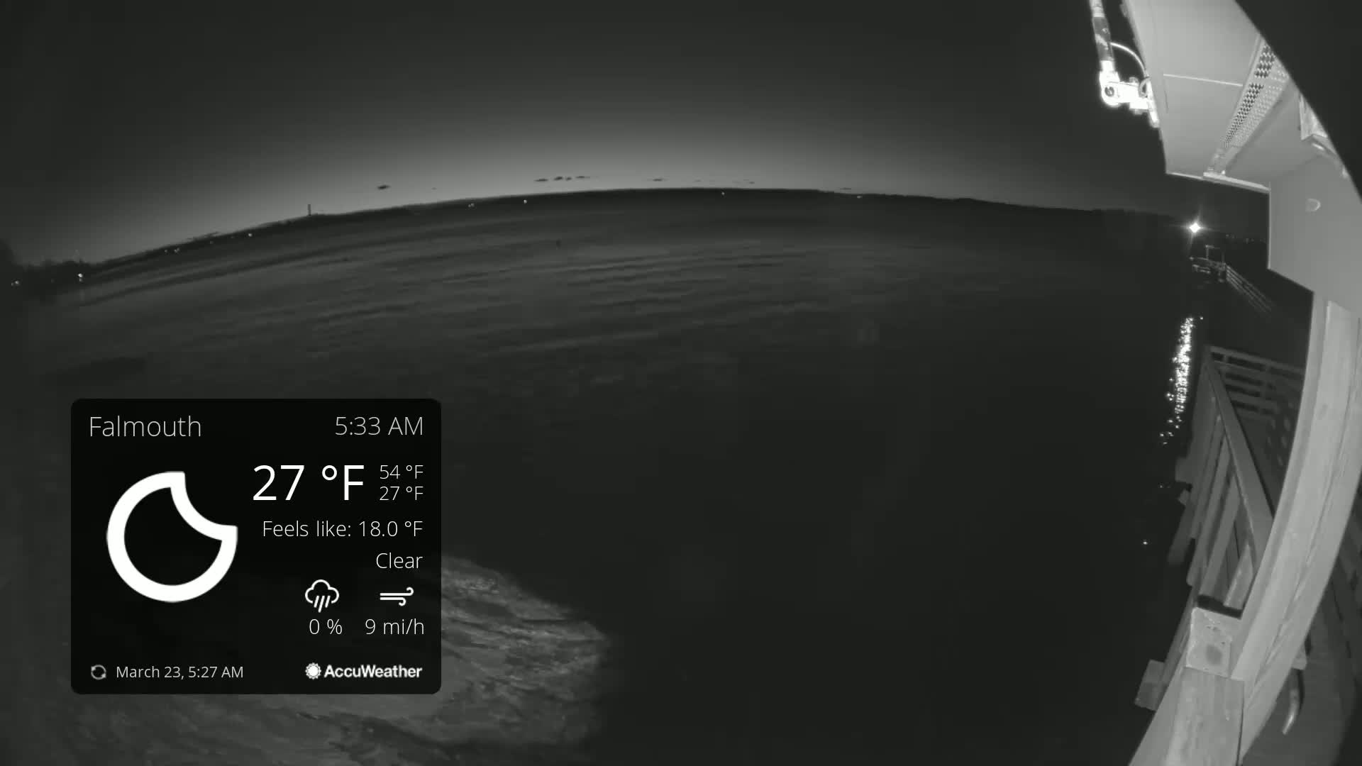 A nighttime, clear view of a calm body of water from a pier, with a slight breeze.
