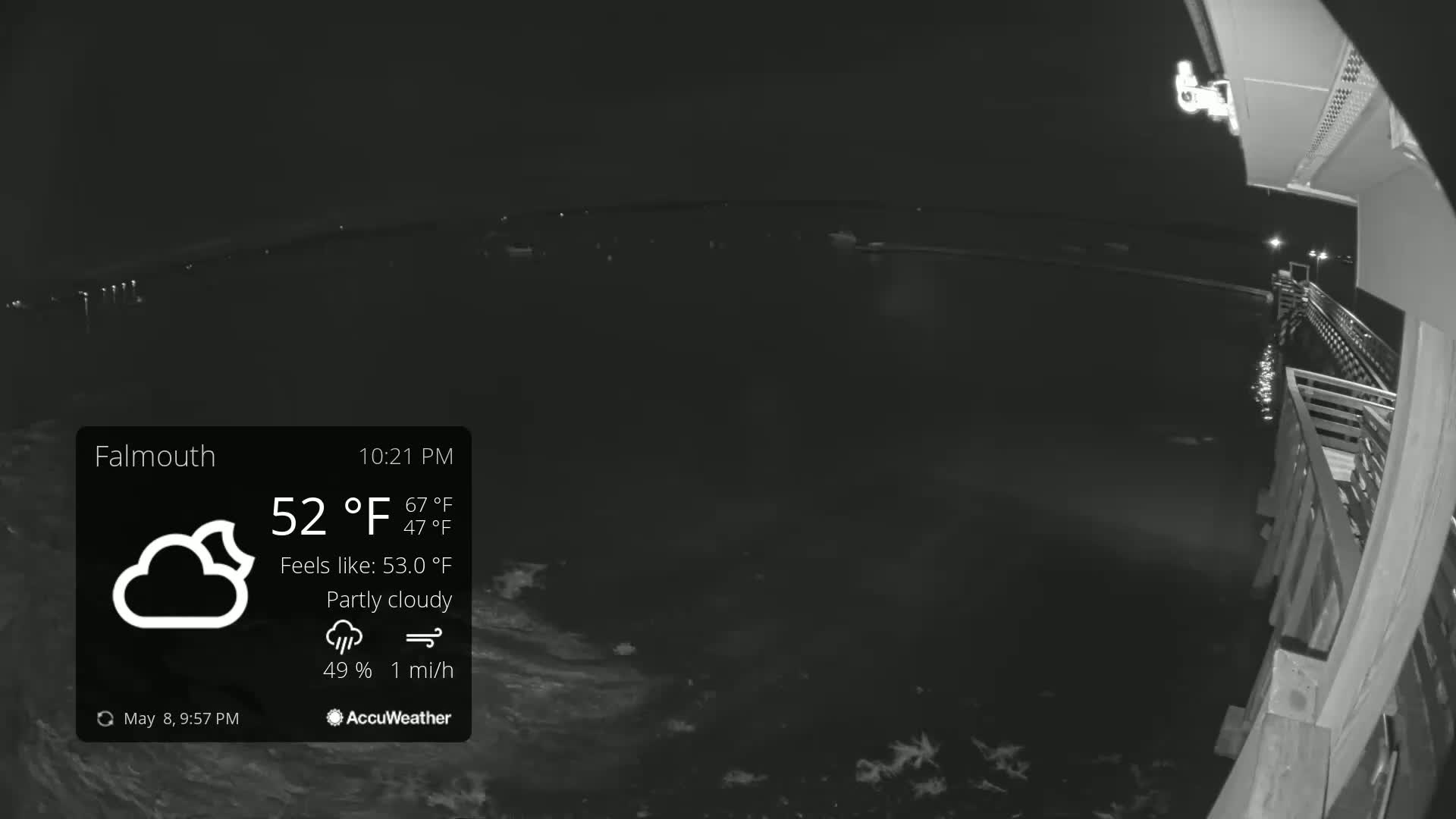 A nighttime, partly cloudy view from a pier shows dark water with a gentle ripple, under a 52°F sky with a 1 mph wind.