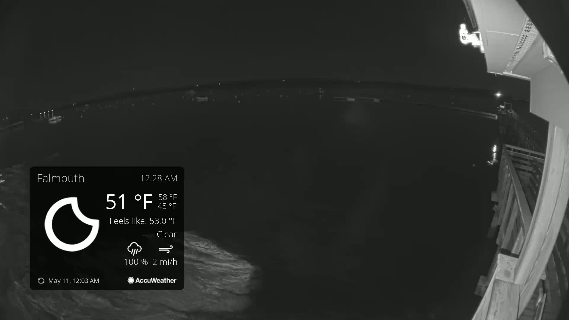 A nighttime, clear view of a dark body of water from a pier, with a slight breeze.