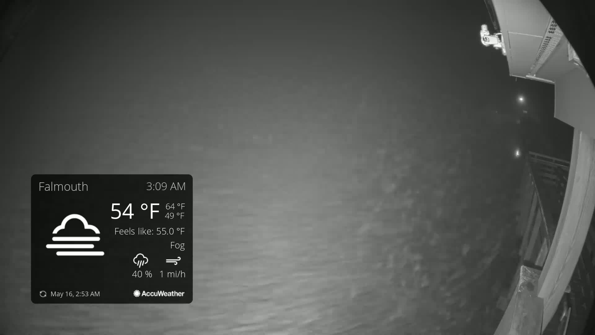 A nighttime, foggy view of water from a high vantage point, with a light breeze.