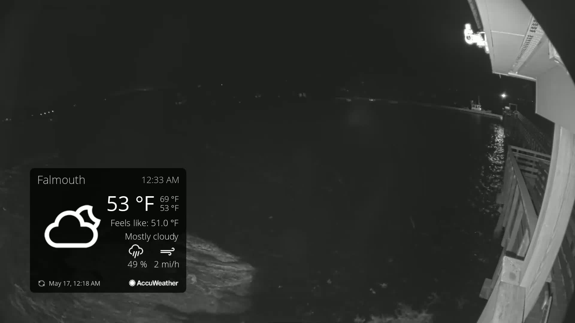 A nighttime, mostly cloudy scene shows a dark body of water next to a wooden pier under a 53°F temperature.