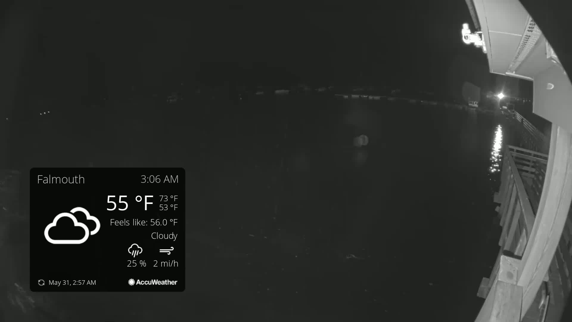 A nighttime, cloudy view from a pier overlooking dark water, with a light breeze.