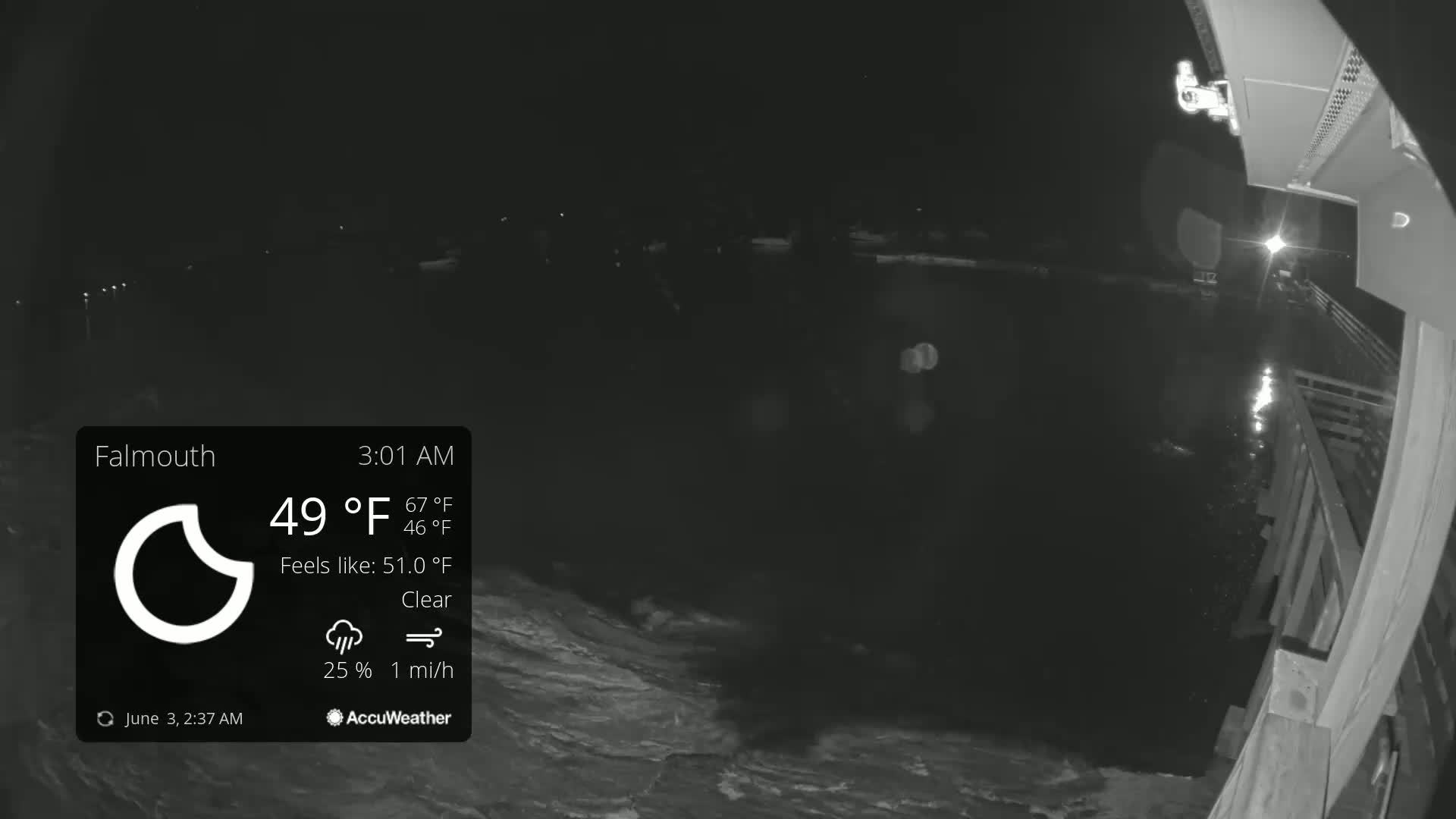 A nighttime, clear view from a bridge overlooking dark water with a slight breeze.