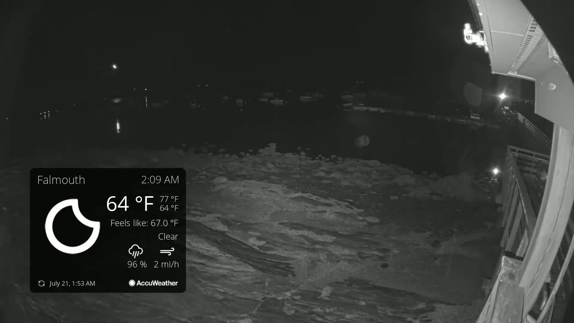A nighttime, clear view of a dark body of water with a partially visible dock or pier under a clear sky.