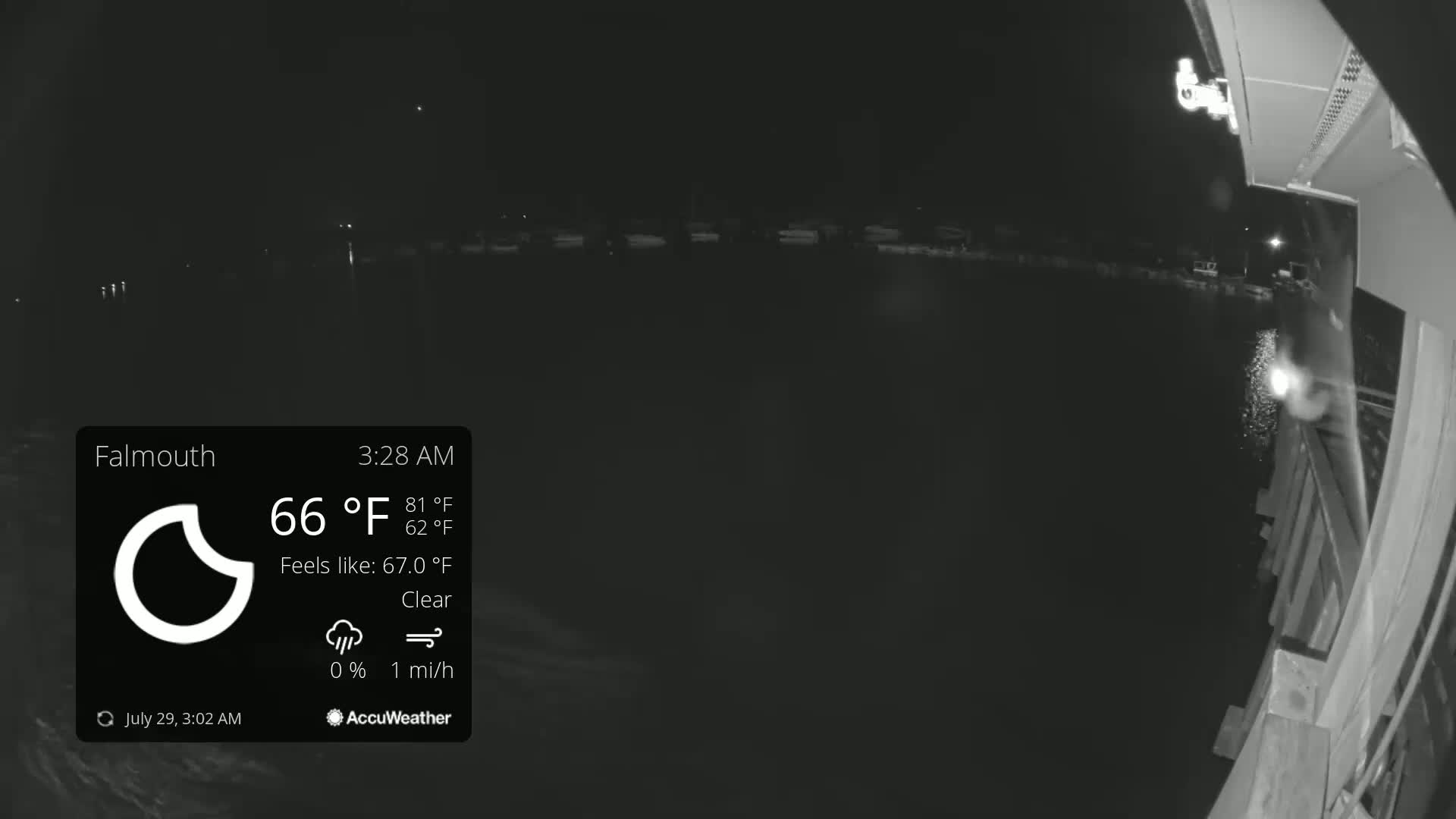A nighttime, clear view of a dark body of water from a dock, with a slight breeze.