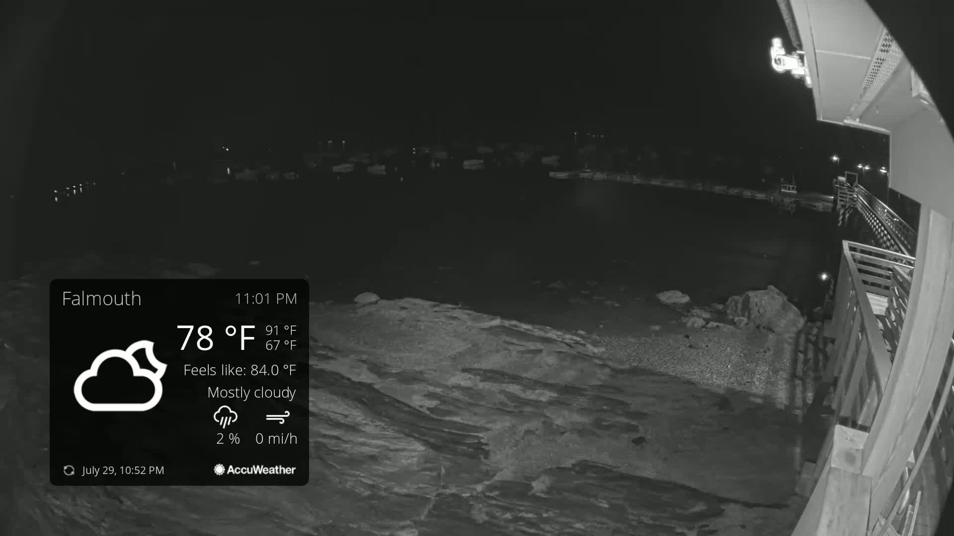 A nighttime, clear view of a dark body of water from a dock, with a slight breeze.