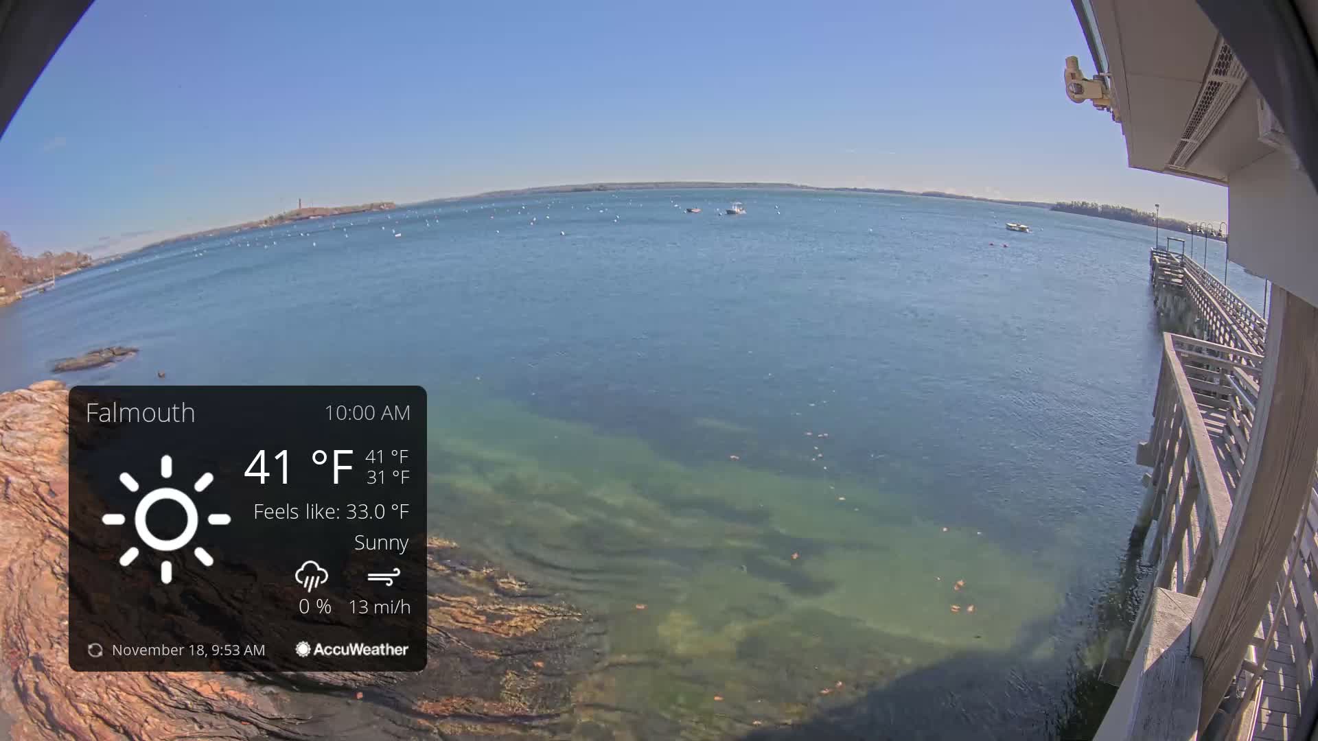 A nighttime, clear view of a dark body of water from a dock, with a slight breeze.