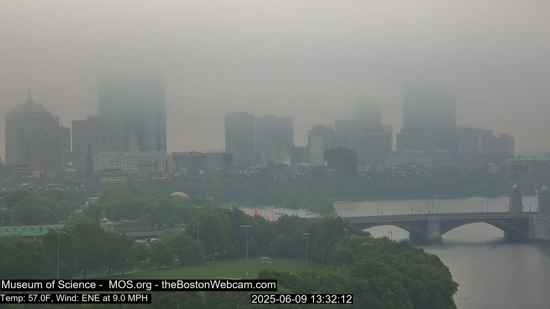 A hazy cityscape with a river and bridge is visible on a foggy day.