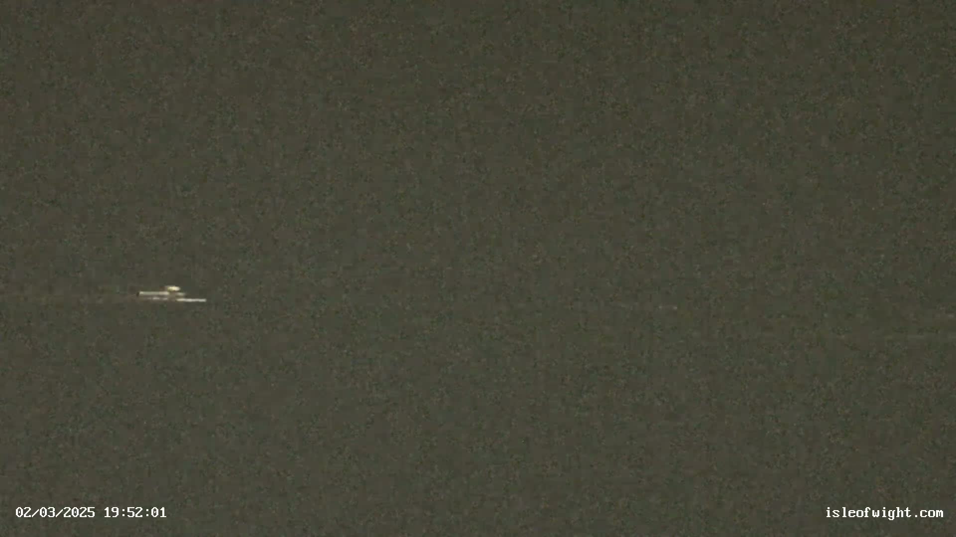 A small, indistinct object is visible in a dark, possibly nighttime, outdoor scene.
