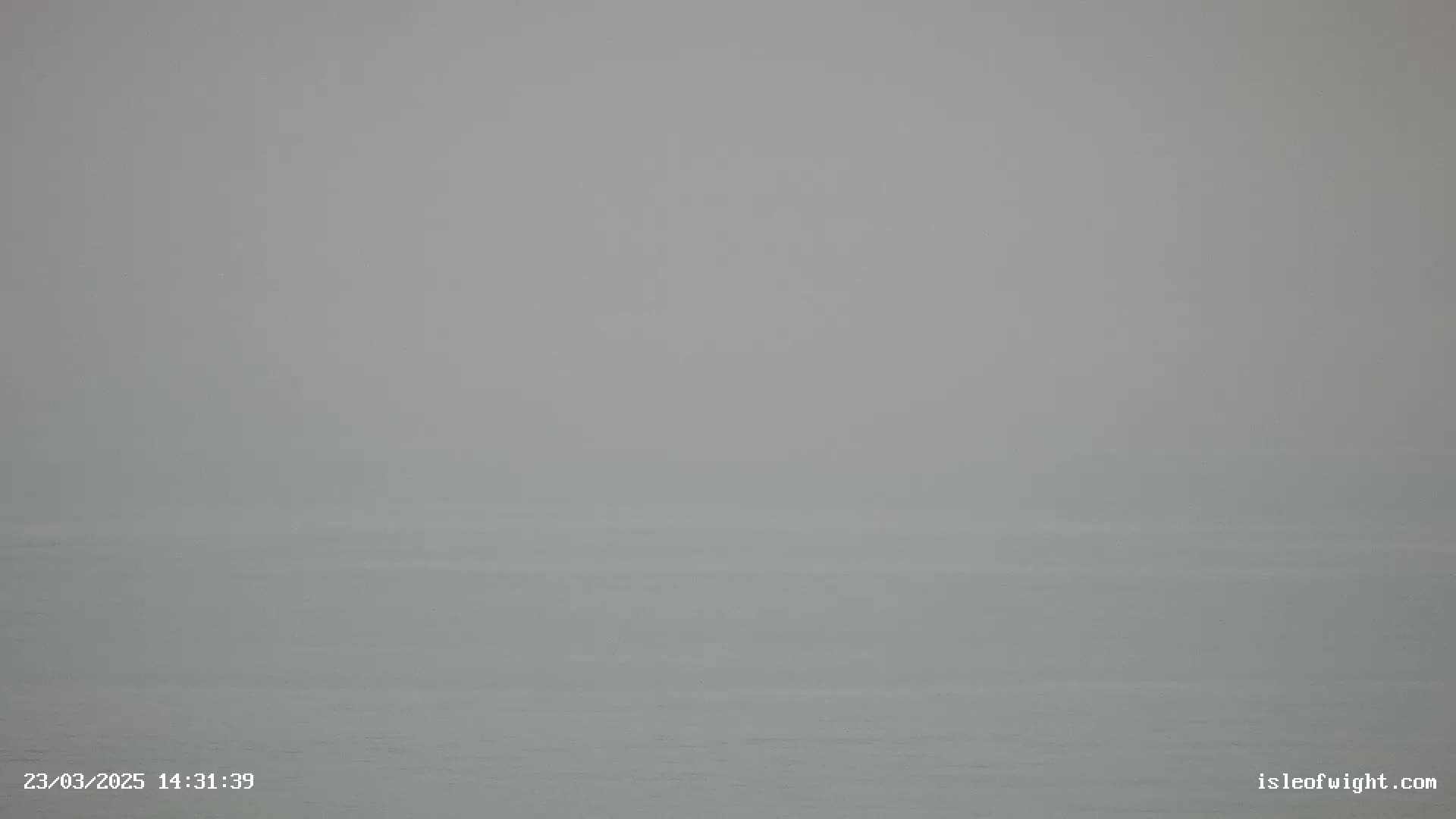 A foggy view of a calm body of water.