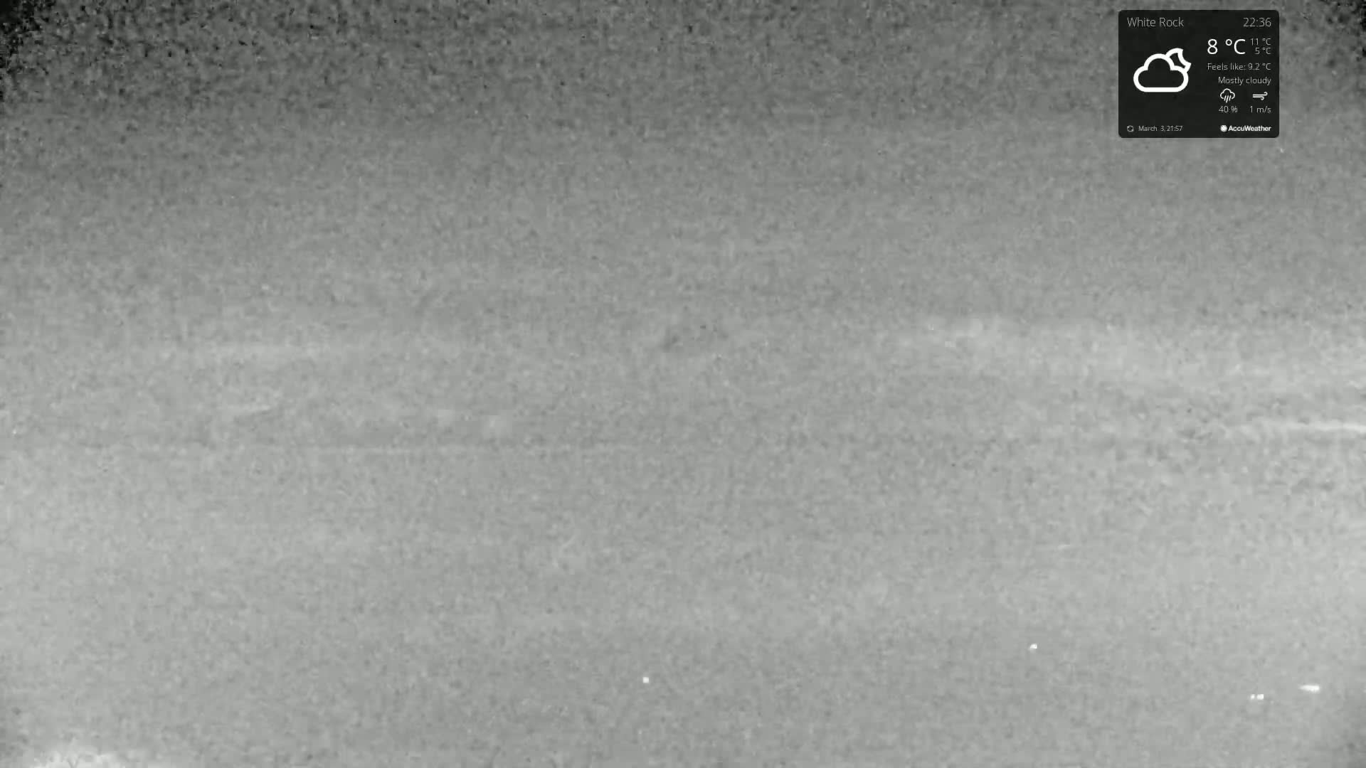 A mostly cloudy night scene shows a dimly lit, flat expanse of land under an 8°C temperature.