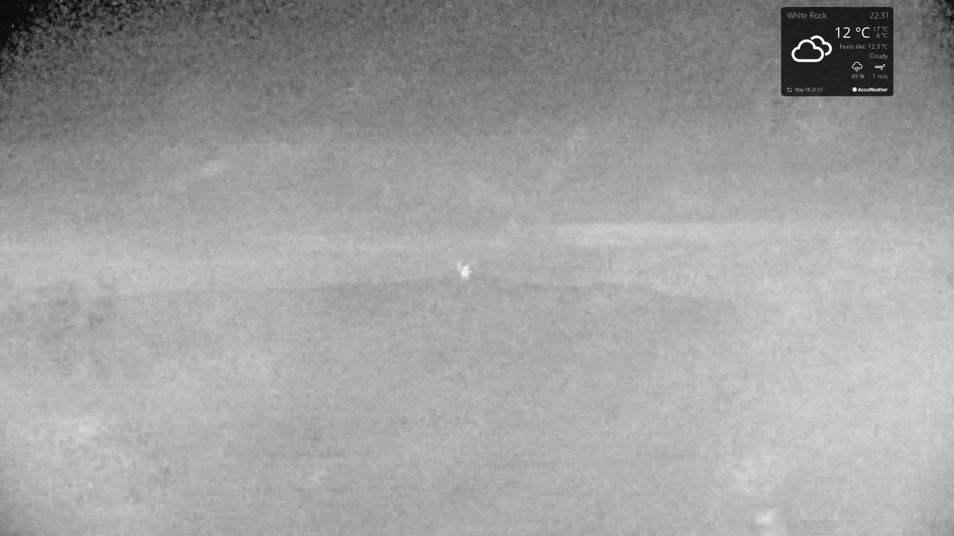 A grainy, nighttime, cloudy outdoor image shows a mostly featureless landscape.