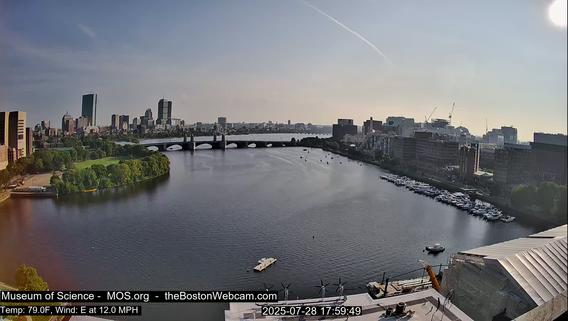 A city skyline with several bridges and a river, under sunny skies.