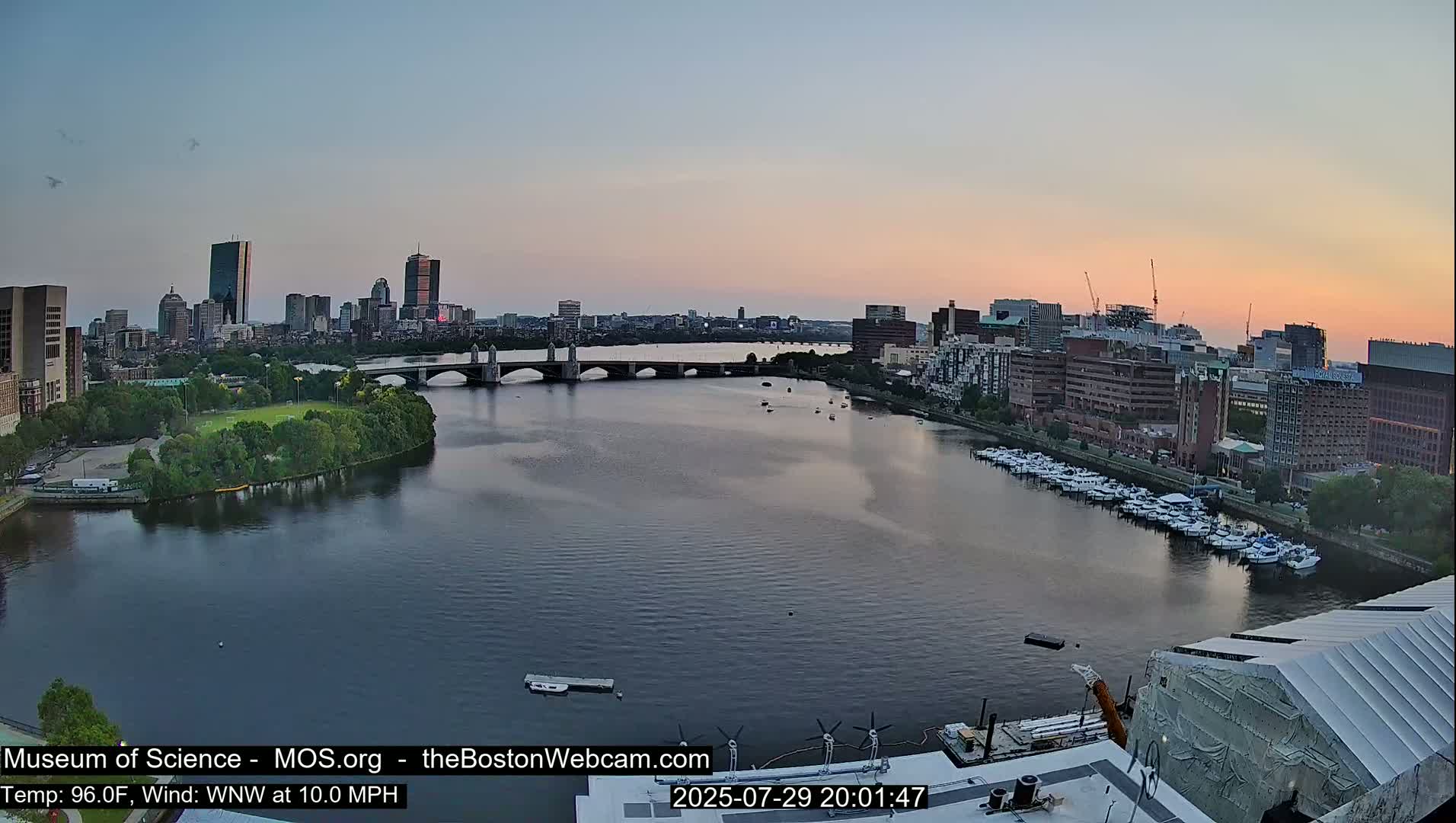 A city skyline with several bridges and a river, under sunny skies.