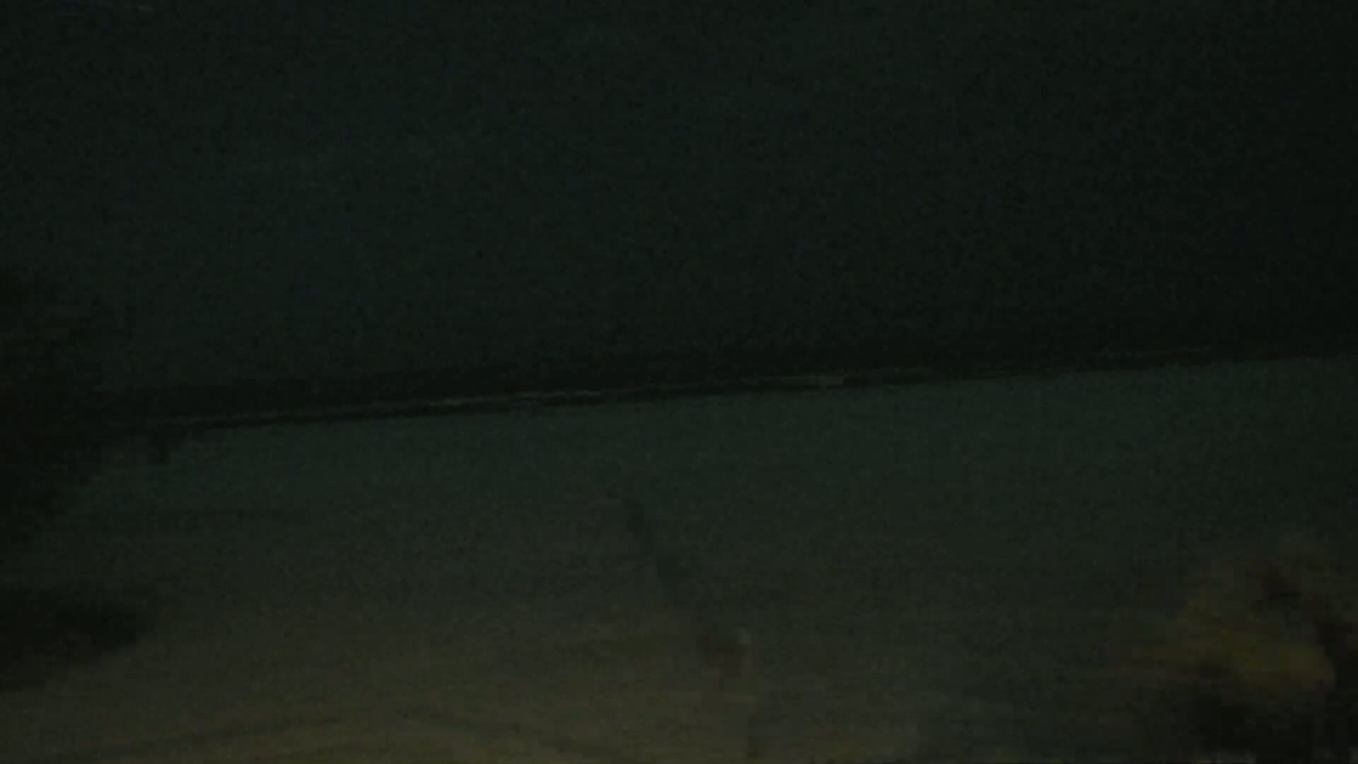 A dark, possibly nighttime scene shows a body of water with a faint horizon line.