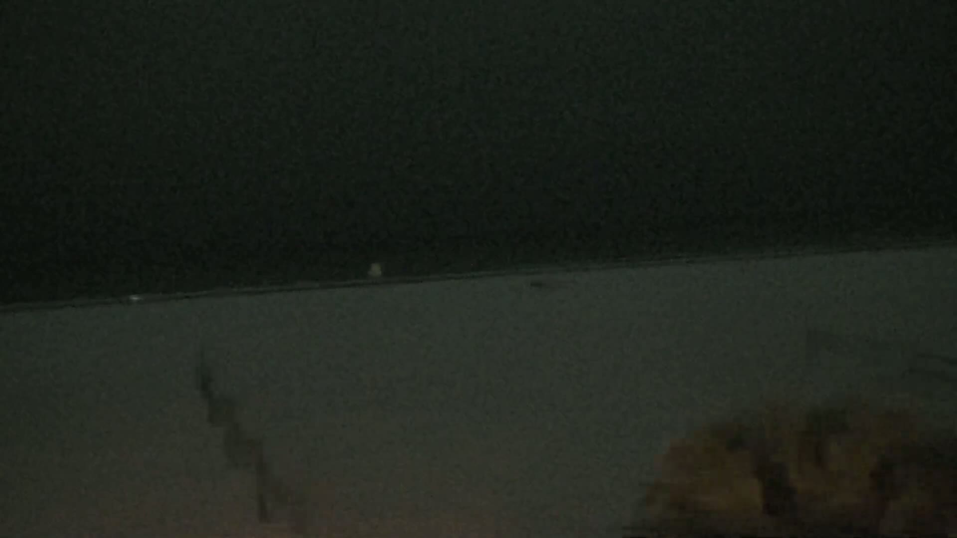 A dark, possibly nighttime scene shows a blurry, indistinct view of what appears to be a beach or shoreline under a dark sky.
