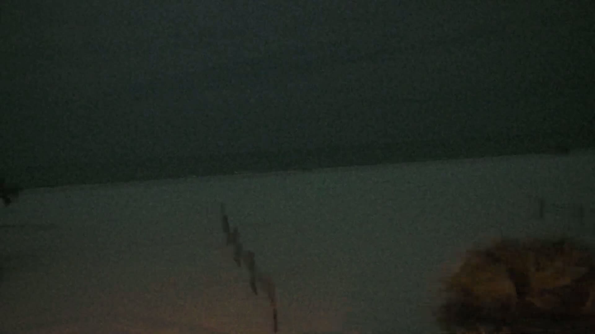 A dark, blurry image shows a dark surface with a small, indistinct object in the lower right corner.