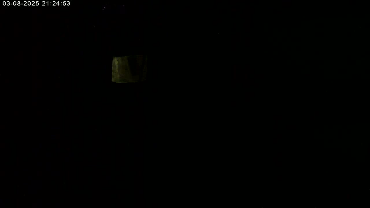 A dimly lit, dark scene shows a small, rectangular area of faint illumination.