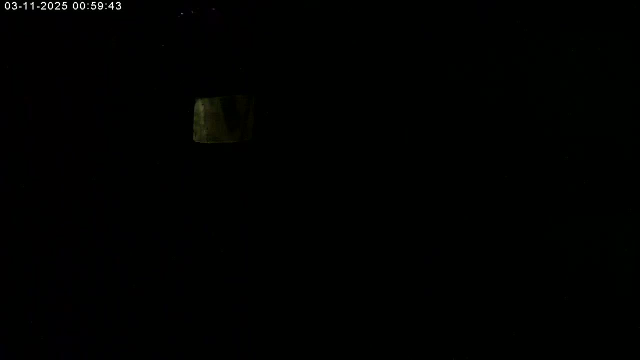 A dimly lit, dark scene shows a small, vaguely rectangular shape in the upper left corner.