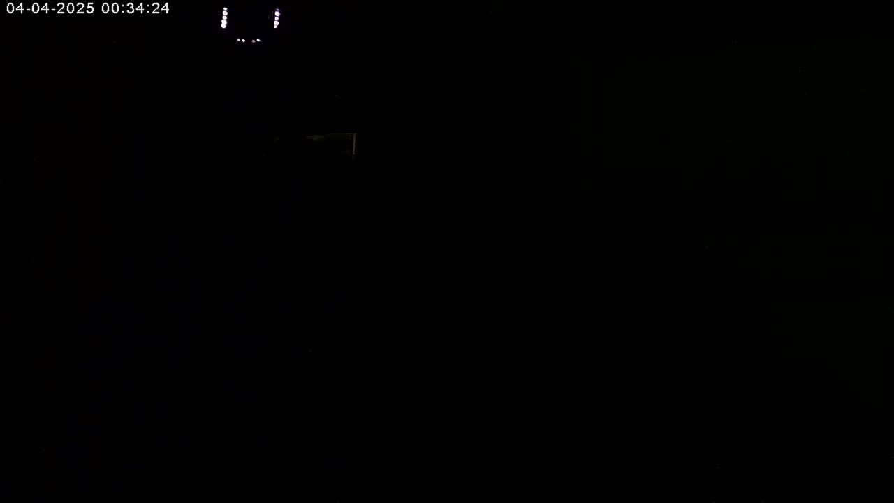 A dimly lit, mostly black scene shows a few faint, small lights at the top.