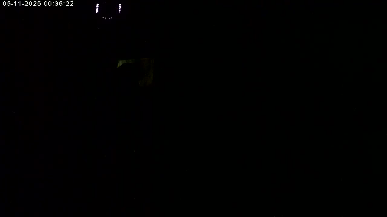 A mostly dark image shows a dimly lit area with a very faint glow in the upper left corner.