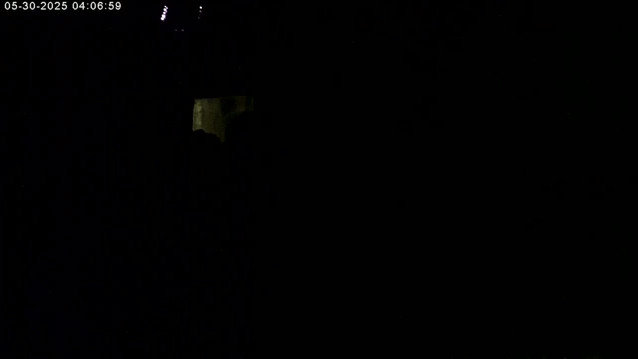 A very dimly lit, dark scene shows a small, faintly illuminated area in the upper left corner.