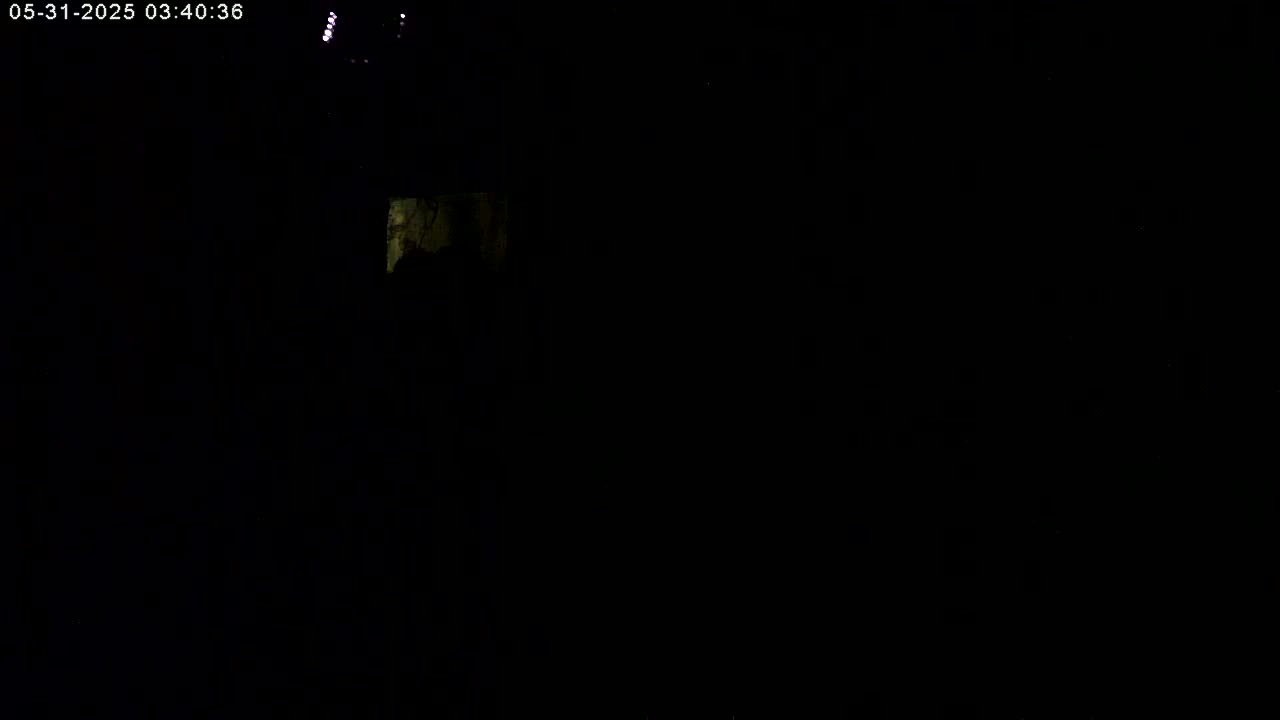 A very dark image shows a small, faintly illuminated area in the upper left corner, suggesting night-time conditions.