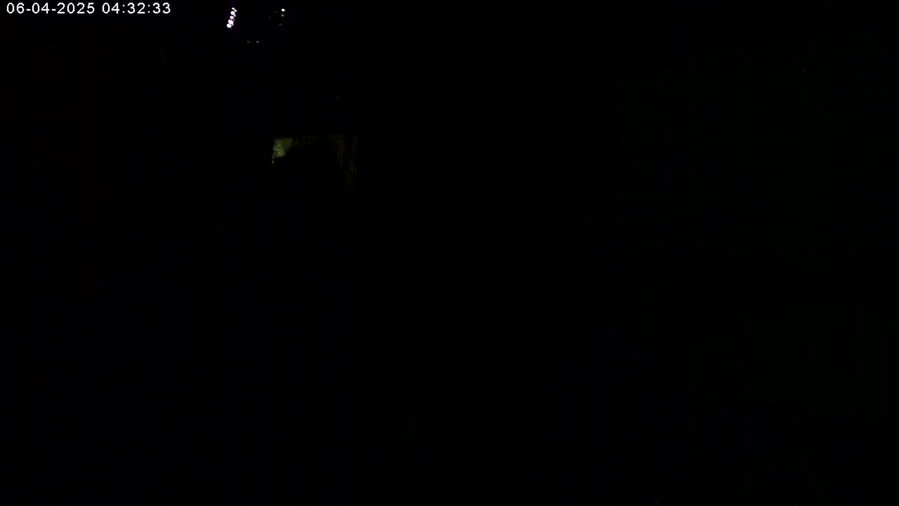The image is almost entirely black, with a few faint, indistinct lights visible in the upper left corner.