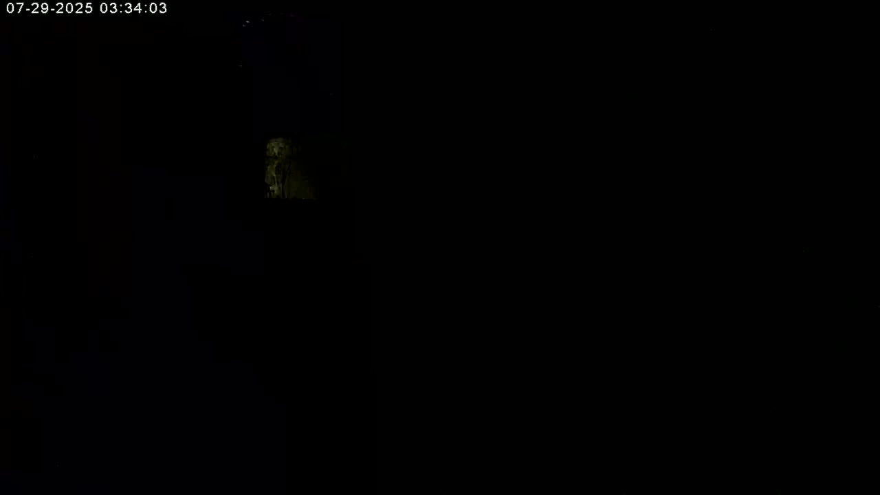 A dimly lit, dark scene shows a small, vaguely illuminated area in the upper-left.