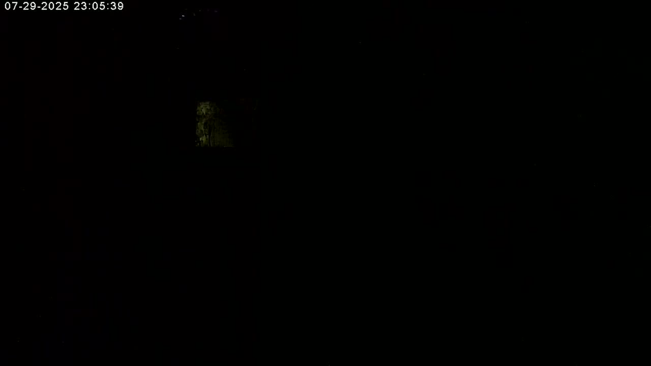 A dimly lit, dark scene shows a small, vaguely illuminated area in the upper-left.