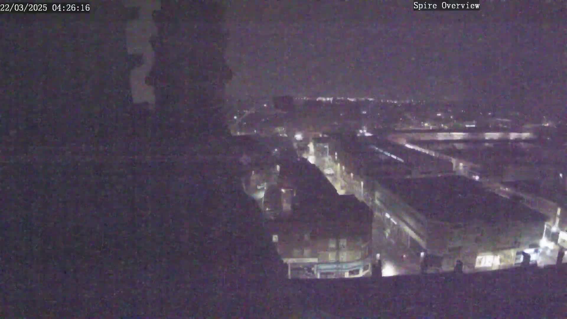 A nighttime, high-angle view of a city with dimly lit streets and buildings.
