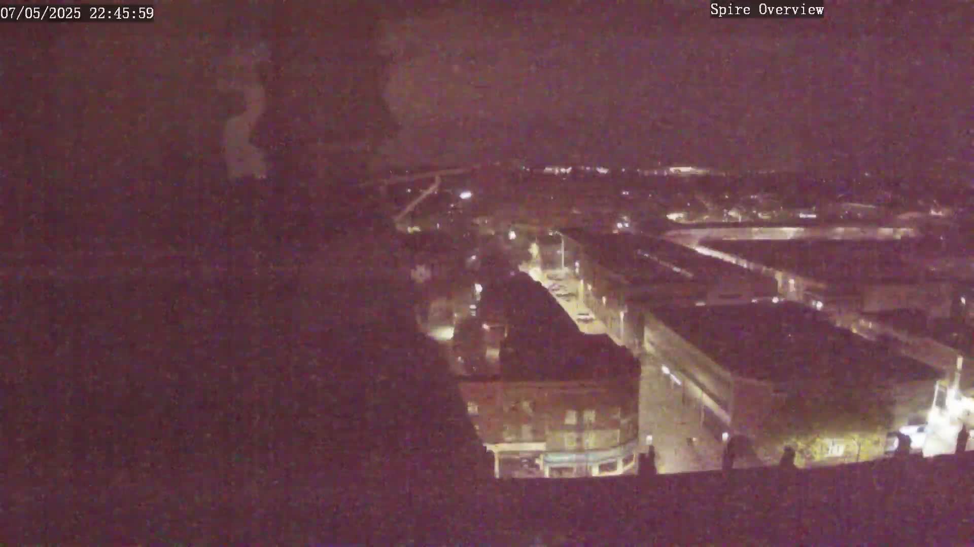 A nighttime, high-angle view shows a city's streets and buildings illuminated by streetlights.
