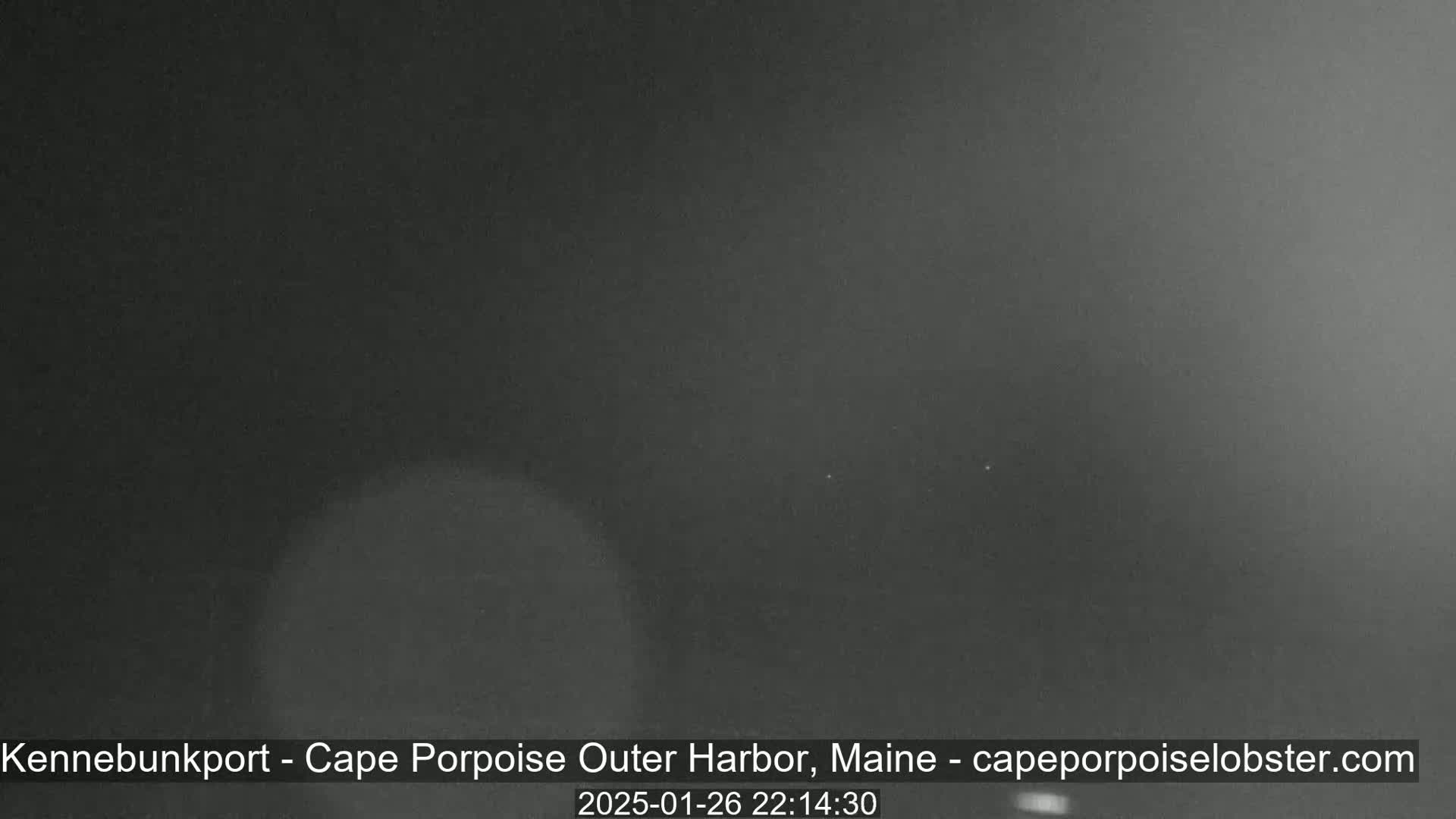 The image shows a dark, nighttime scene, possibly an outdoor harbor, with poor visibility due to dark conditions.