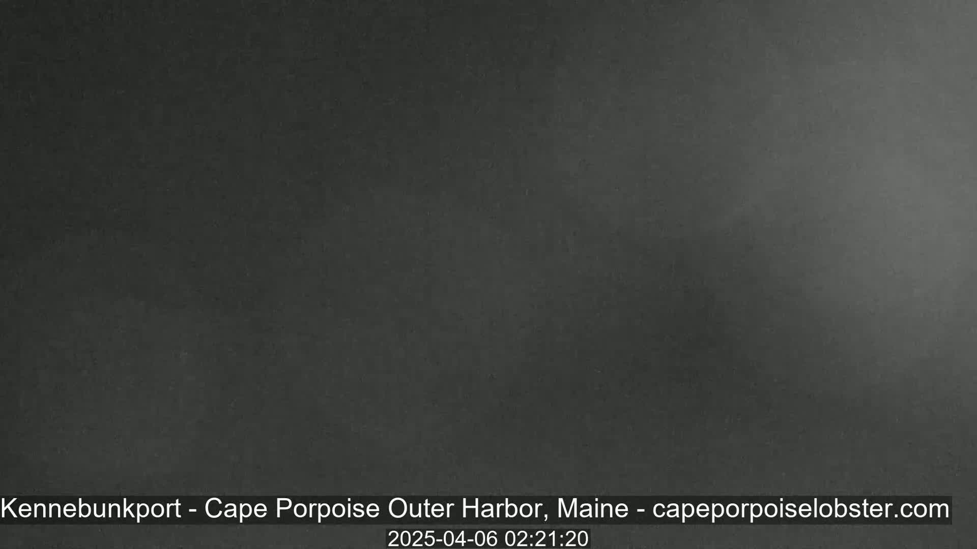 A dark, uniformly colored image shows an overcast sky at night.