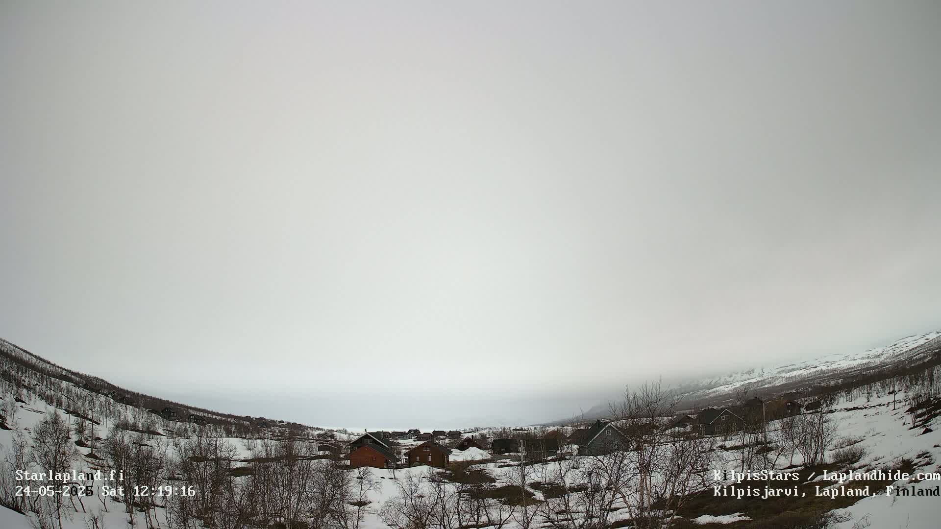 A small village nestled in a snow-covered valley under an overcast sky.