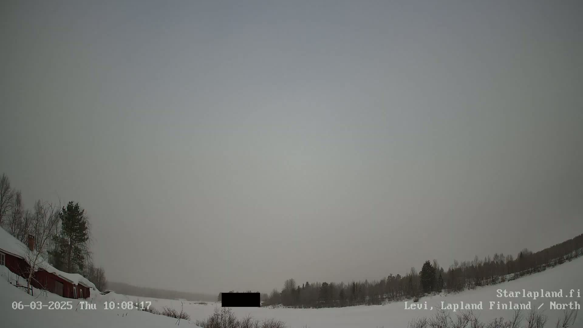 A snow-covered landscape with a red building and trees is visible under an overcast sky.