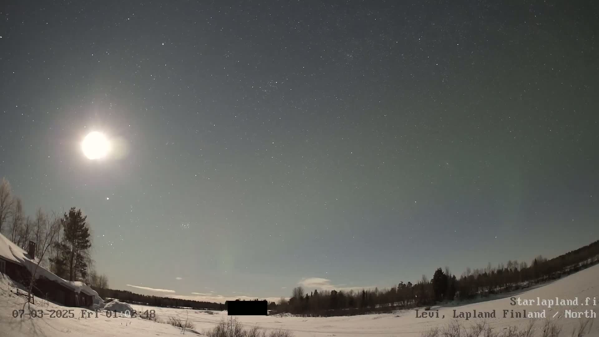 A bright moon illuminates a snowy landscape under a starry night sky.
