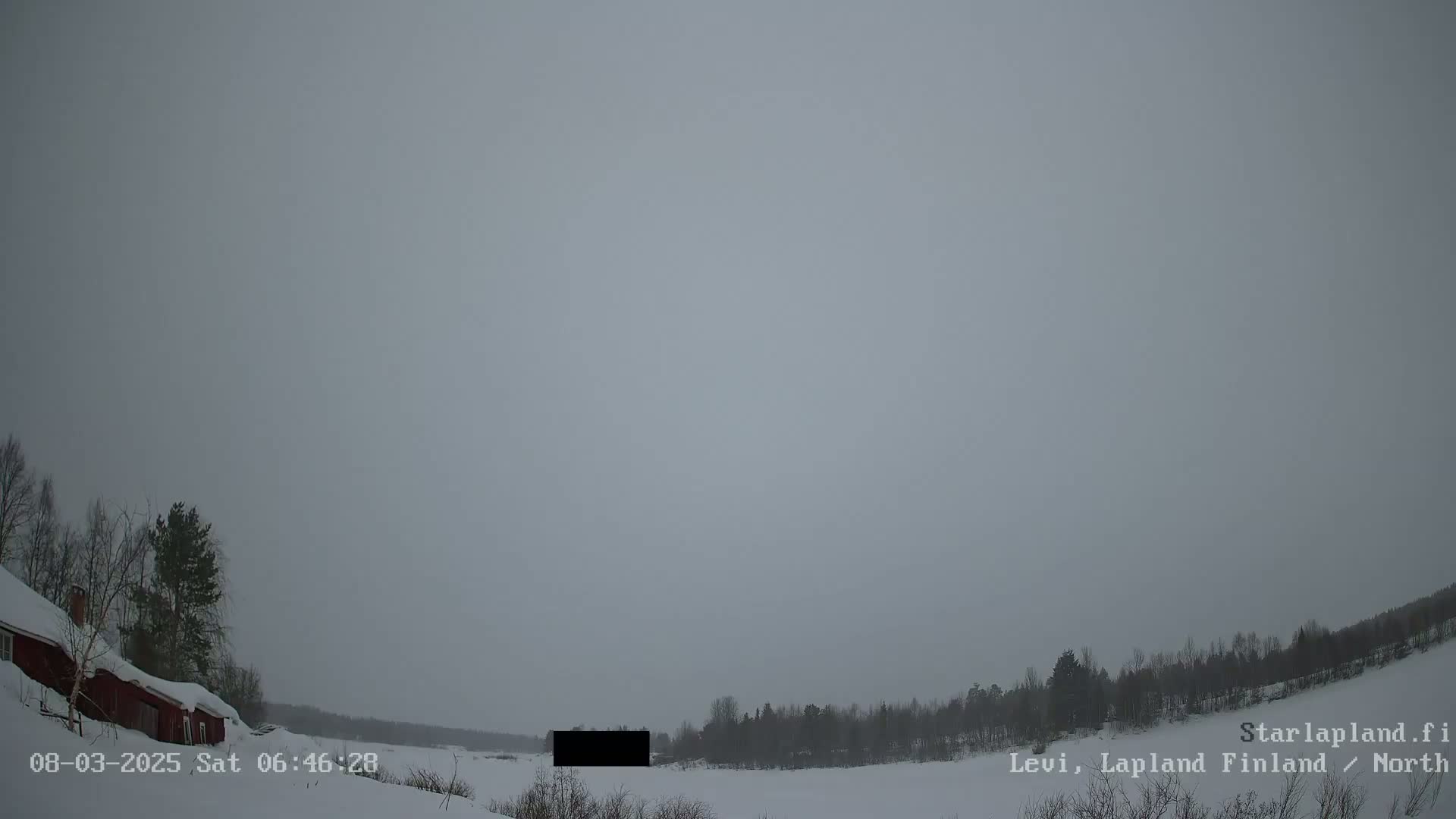 A snow-covered landscape with a red house and trees under an overcast sky.